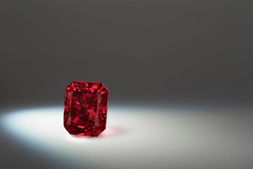 This truly beautiful, deep red, radiant-cut diamond is also spotlit from the left in a dark space