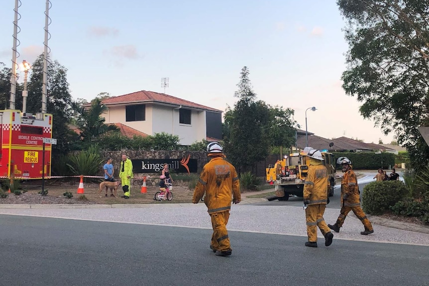 Blackened firefighters walk through the incident control centre at Peregian Springs.