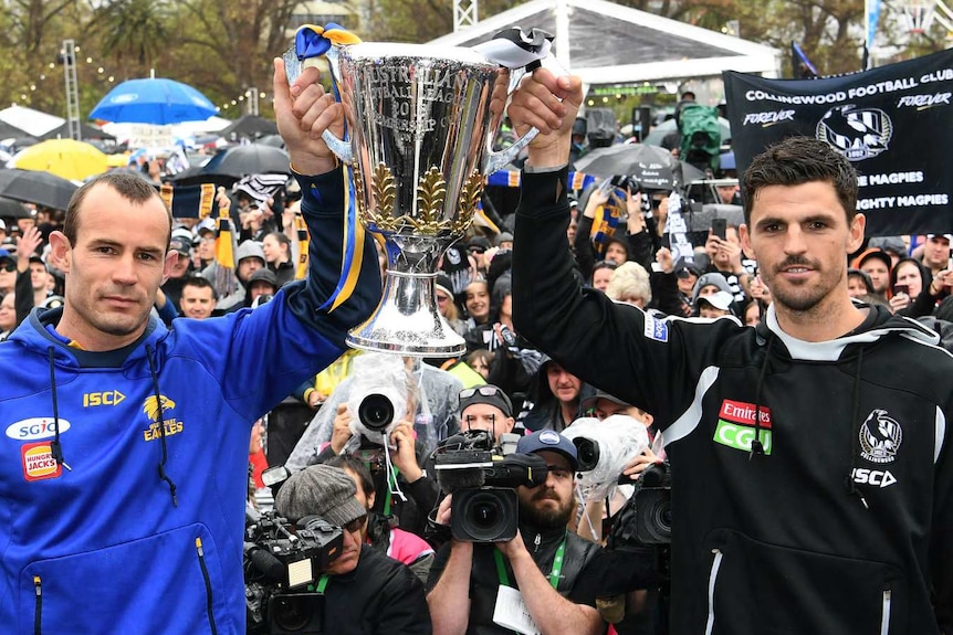 West Coast captain Shannon Hurn and Collingwood captain Scott Pendlebury hold the premiership cup at the grand final parade.