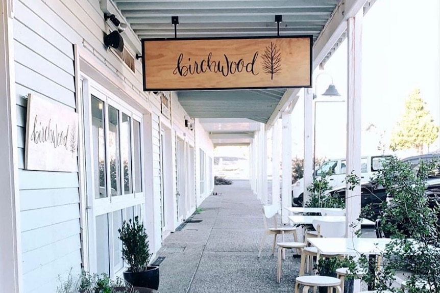 A cafe sign with seating ouside