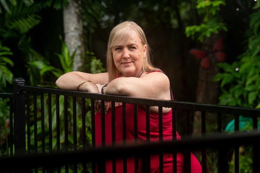 Annemarie Lloyd stands against a fence in her backyard.