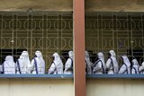 Group of nuns stand on a balcony, all facing away