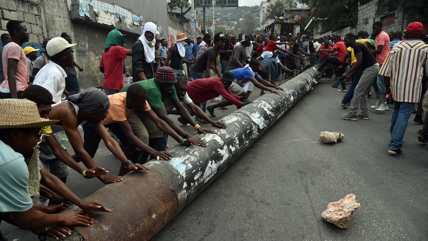 Demonstrators used a pylon to block a street in Port-au-Prince, Haiti.