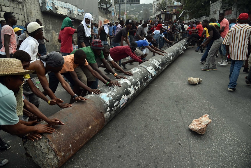Demonstrators used a pylon to block a street in Port-au-Prince, Haiti.