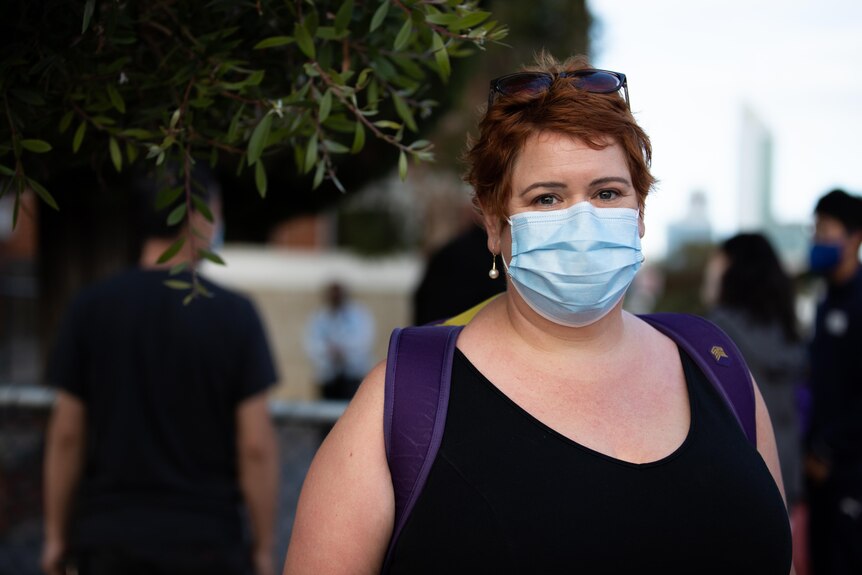 Sam Maisey pictured outside Highgate Primary wearing a mask and a school bag on her back