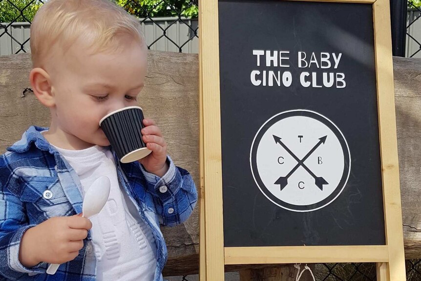 A toddler enjoys a baby cino.