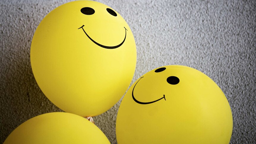 Three yellow balls with smiley faces