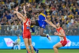 West Coast Eagles ruckman Nic Naitanui leaps for a mark sandwiched by two Sydney Swans players at Perth Stadium.