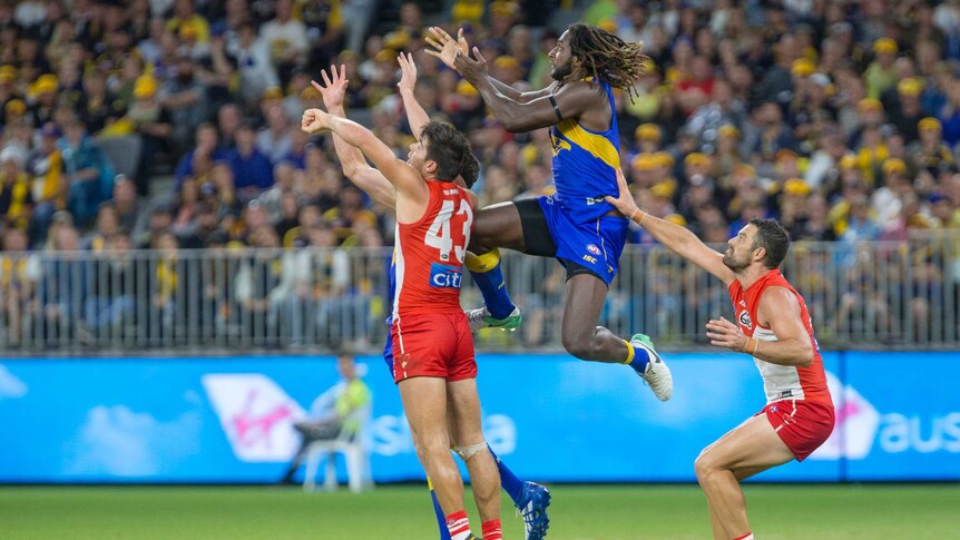 West Coast's Nic Naitanui (C) leaps for the mark against the Sydney Swans in Perth.