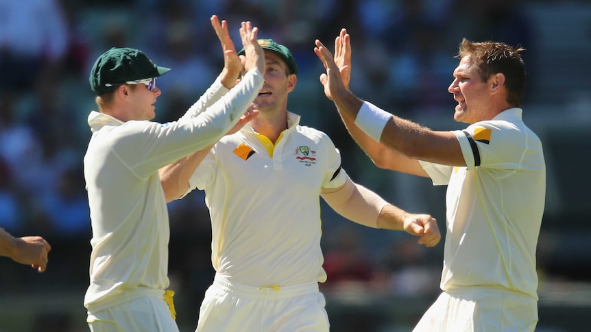 Australia's Ryan Harris and Steve Smith celebrate the wicket of Shikhar Dhawan on day two at MCG.