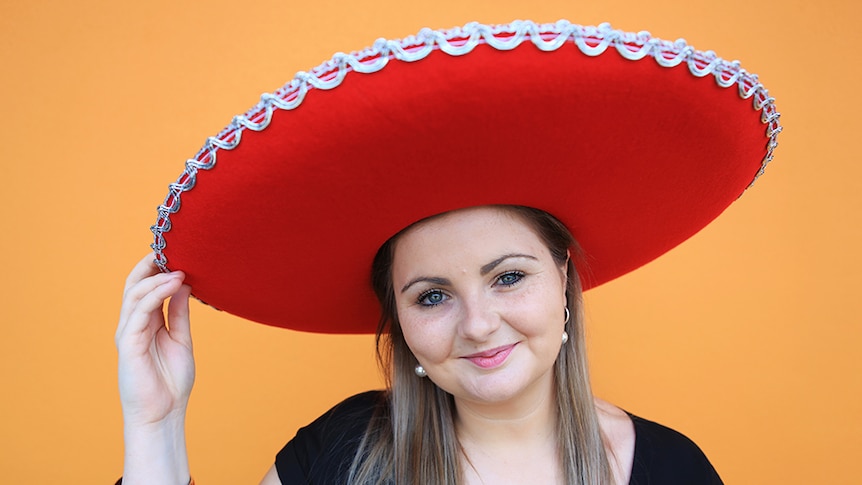 Kate Baines poses with a large red hat and is the organiser of the campaign #hatsforharry