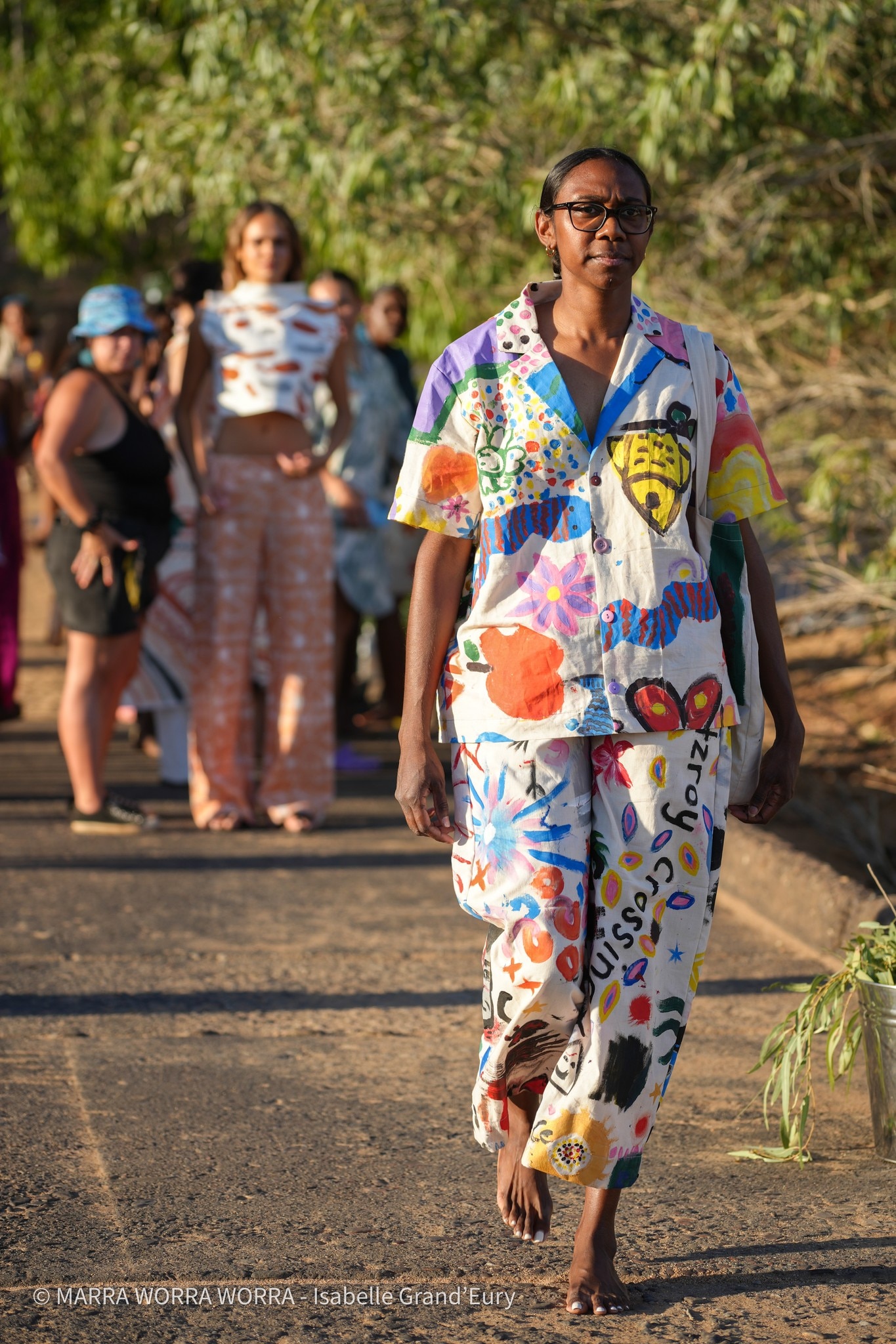 uma mulher com óculos e uma camisa estampada colorida 