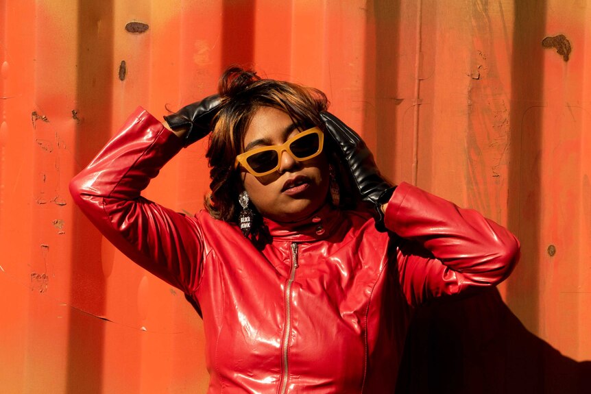 Emily Wurramara wearing a red leather jacket, black leather gloves and sunglasses