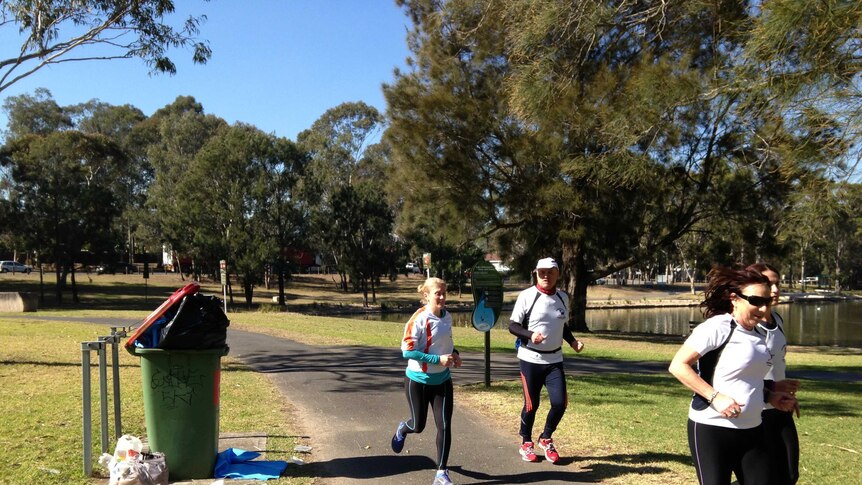 Joggers run past litter in Henry Lawson Reserve