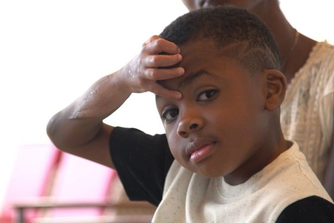 Zion Harvey is pictured looking at the camera, with surgical scars visible on one arm.