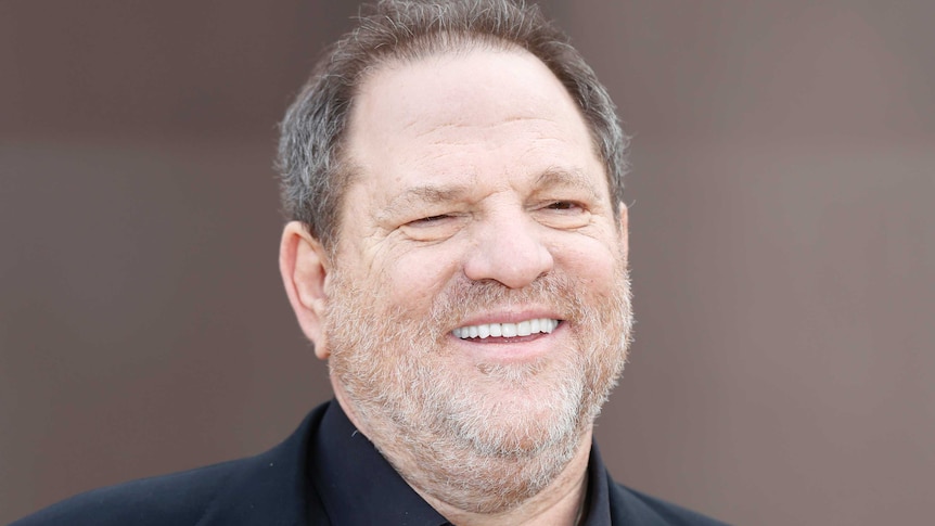 Harvey Weinstein grins on the red carpet