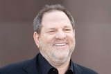 Harvey Weinstein grins on the red carpet