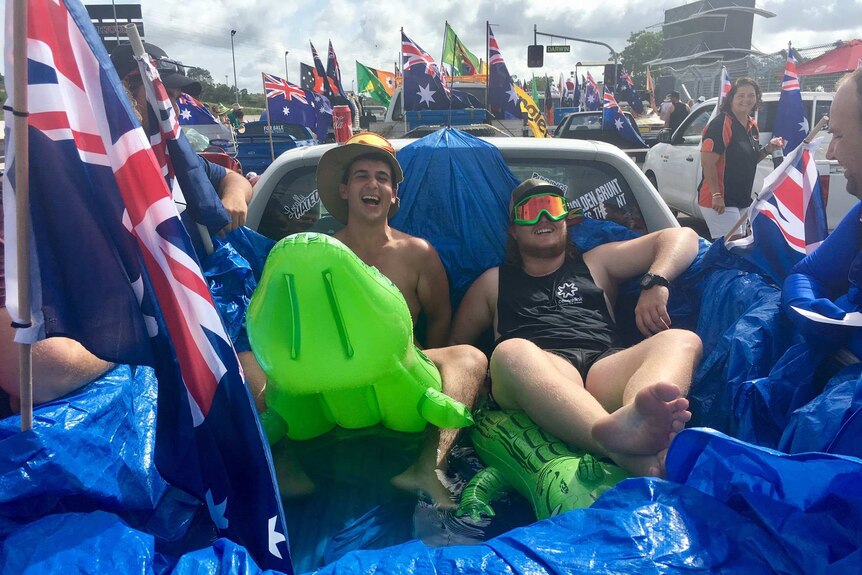 Men sitting in the tray of ute filled with water at Darwin's Australia Day Ute run.