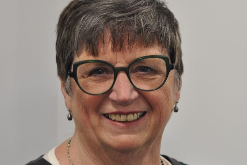 A bespectacled woman with grey hair