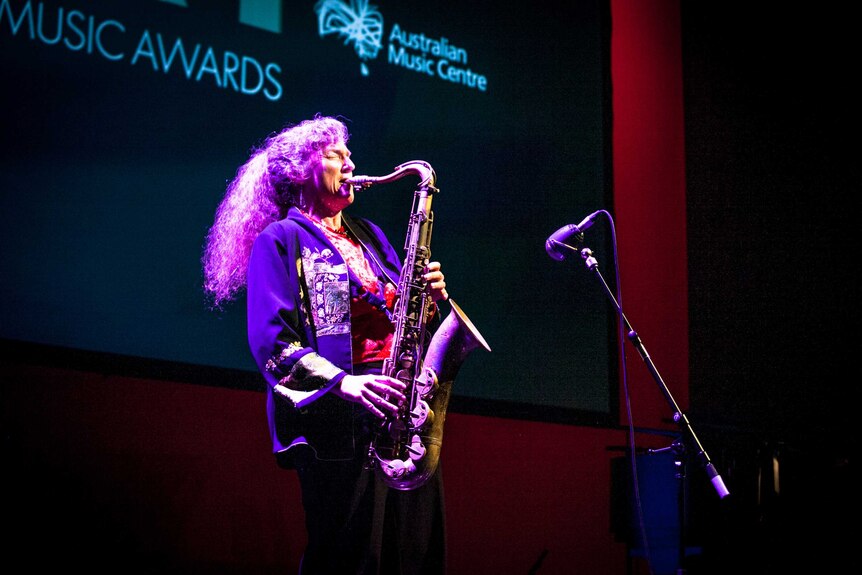 Woman plays saxophone on stage