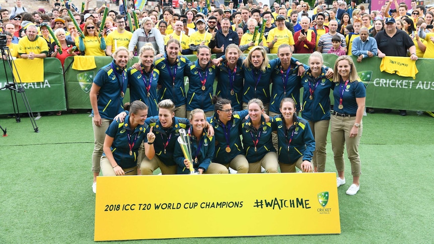 The Australian women's cricket team poses in Melbourne with the ICC T20 World Cup trophy.
