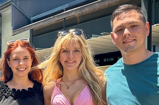 Three young people smiling outside the Cairns cruise terminal