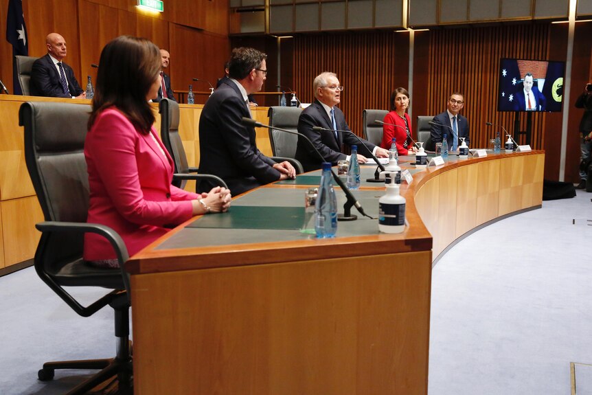 Les chefs du Cabinet national sont assis dans des sièges à gradins avec Mark McGovan sur un écran