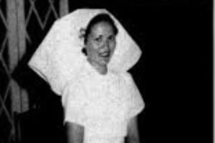 A black and white image of a woman in an old-fashioned white nursing uniform
