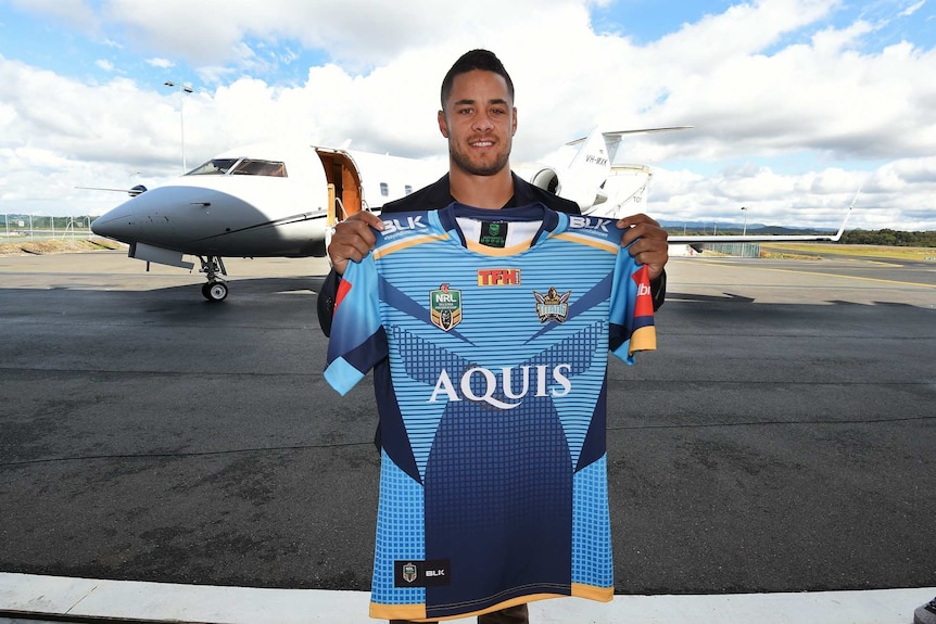 Hayne poses with a Titans jersey at the airport