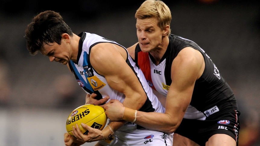 Tight tussle ... Port Adelaide's Jasper Pittard battles to get away from St Kilda captain Nick Riewoldt.