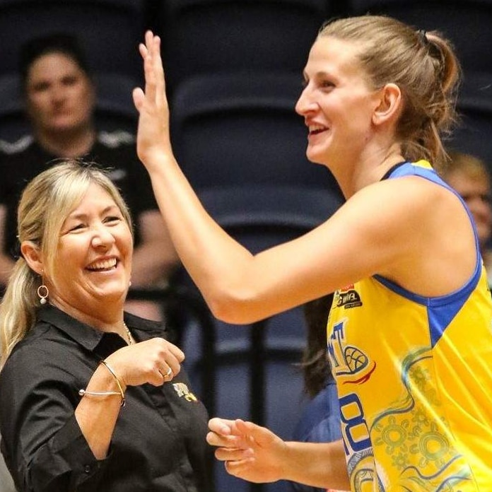 Basketball player from Bendigo Spirit high fives Lead Assistant Coach Mark Alabakov and Head Coach Tracy York.