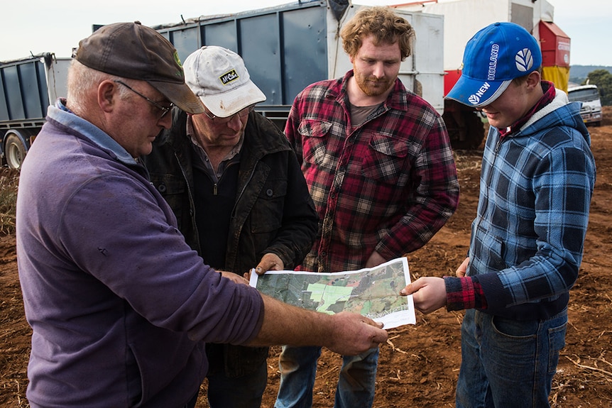 Rodney and Darryl Saltmarsh show a map of the planned UPC line to some of their potato pickers