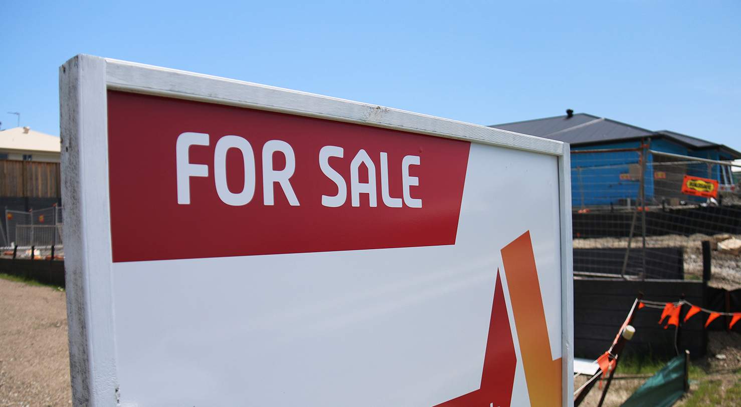 For sale sign at vacant land at house site.