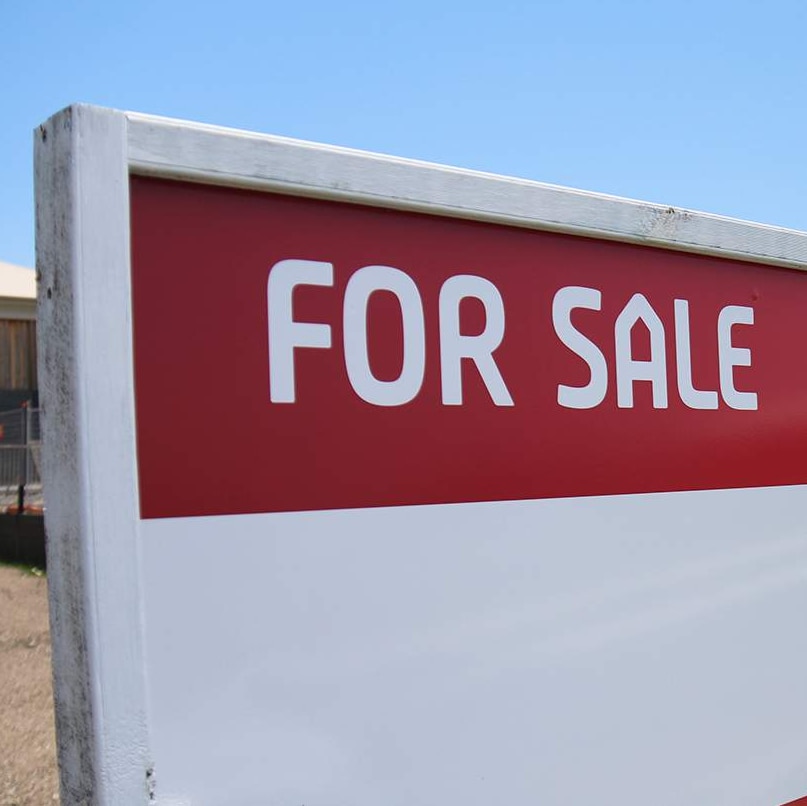 For sale sign at vacant land at house site.
