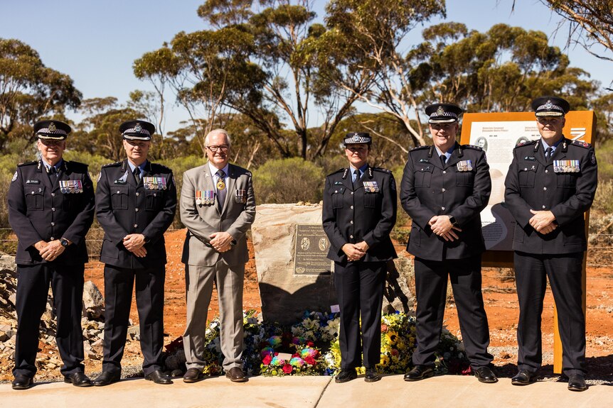 High-ranking police officers at a memorial to fallen officers.  