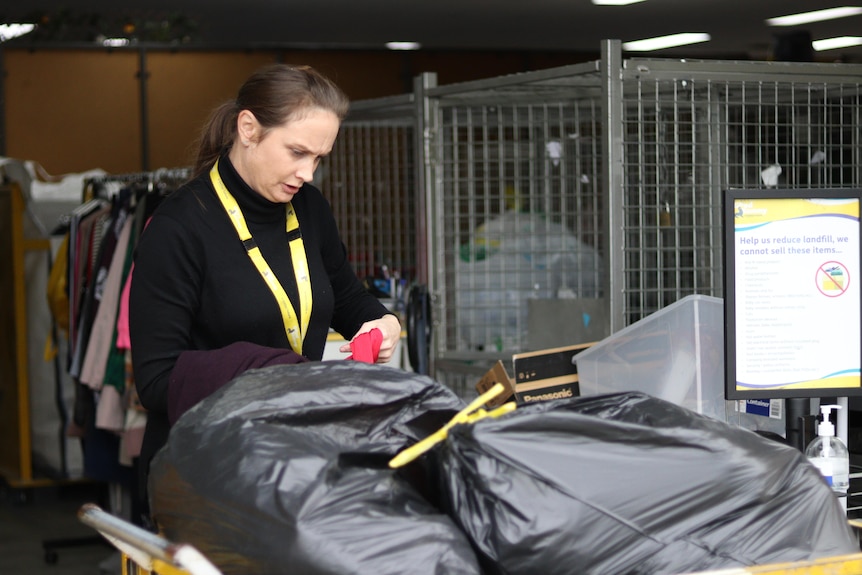 A woman dressed in black organizations donated clothes. 