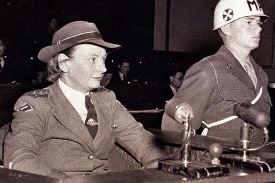 Old photograph of young woman serious with microphone and soldier beside her