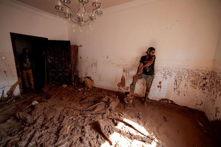 A man standing in a room filled with mud