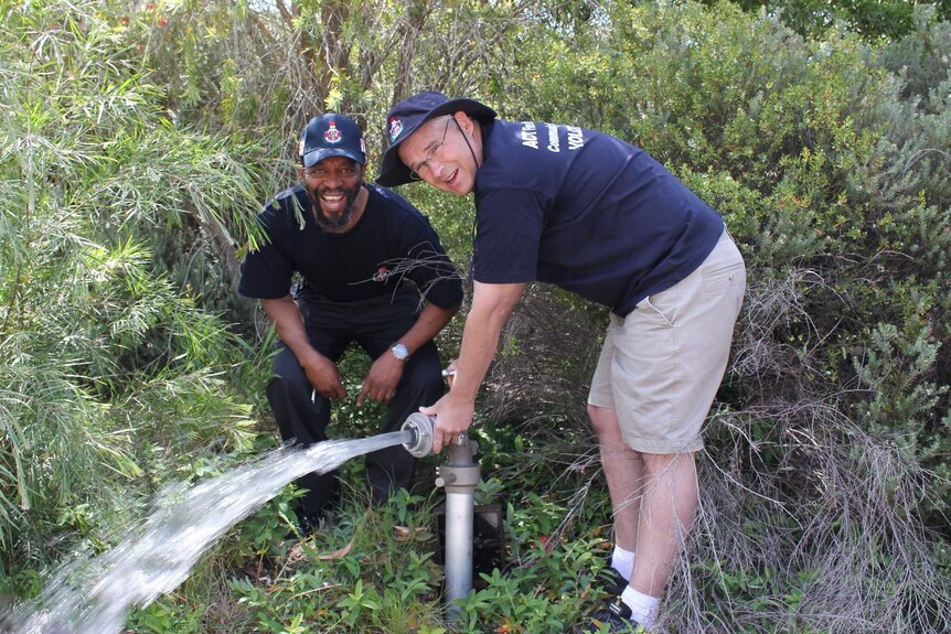 Jabulane Matsebula and David Bundy from the Fadden Community Fire Unit check a fire hydrant.