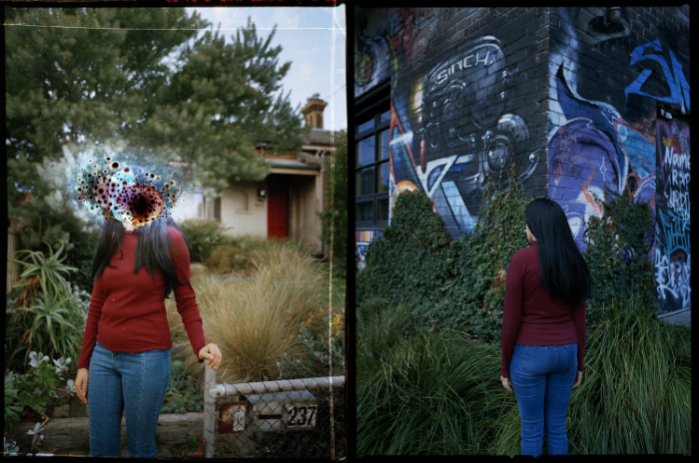 A woman standing in front of a house and graffitied wall with her face obscured