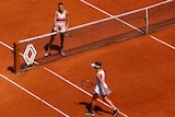 Aryna Sabalenka waits at the net after winning her quarter final match as Ukraine's Elina Svitolina walks past