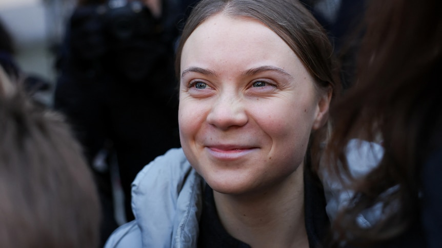 Close up of Greta Thunberg smiling. 