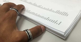 A hand next to a list of names on paper