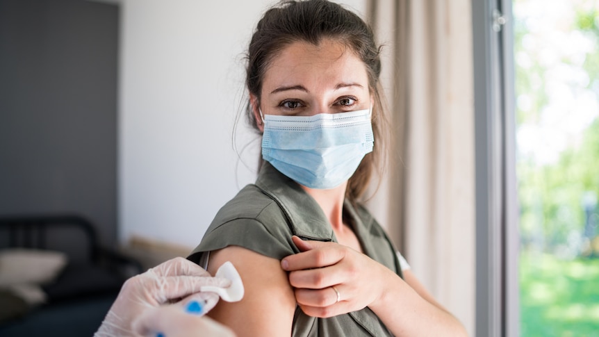 Young woman with face mask getting vaccinated.
