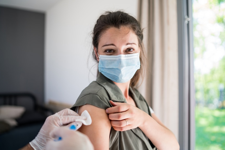 Young woman with face mask getting vaccinated.