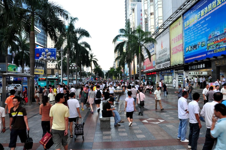 People walk along the street in Shenzhen, China.