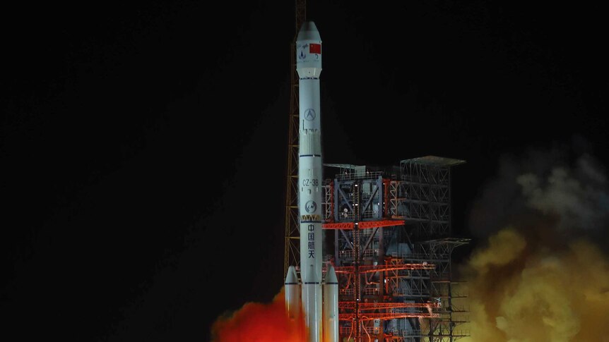 The Chang'e 4 lunar probe launches from the the Xichang Satellite Launch Centre with flames and smoke coming out of it.