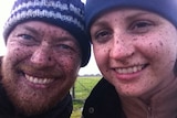 Couple smiling with mud splatters.