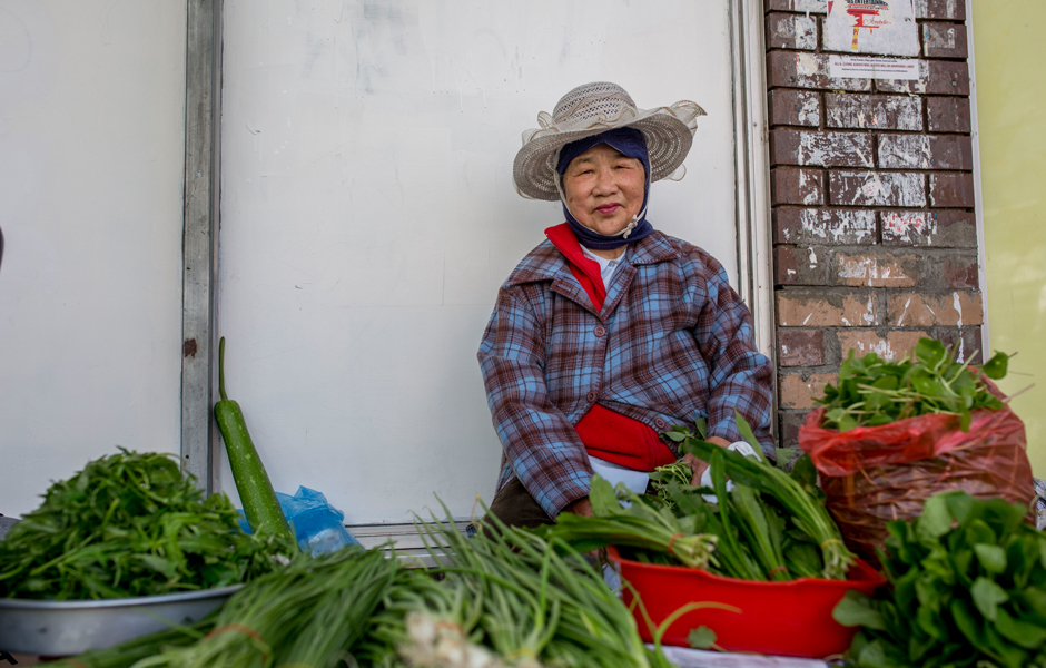 Vietnamese woman Tem Ho selling her home-grown vegetables on the street.