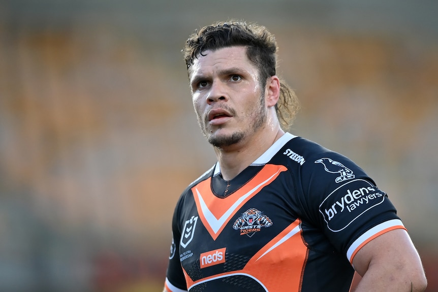 A Wewsts Tigers NRL player looks to his left during a match.